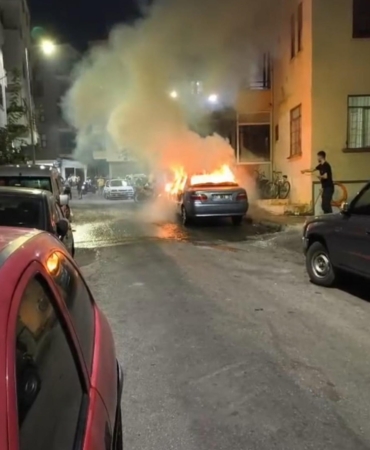 Yanan otomobili, balkondan kovalarla su dökerek söndürdüler