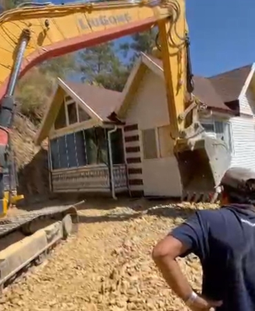 Yıkım kararı verilen konteyner evini iş makinesiyle karadan rayla yürütüp taşıdı